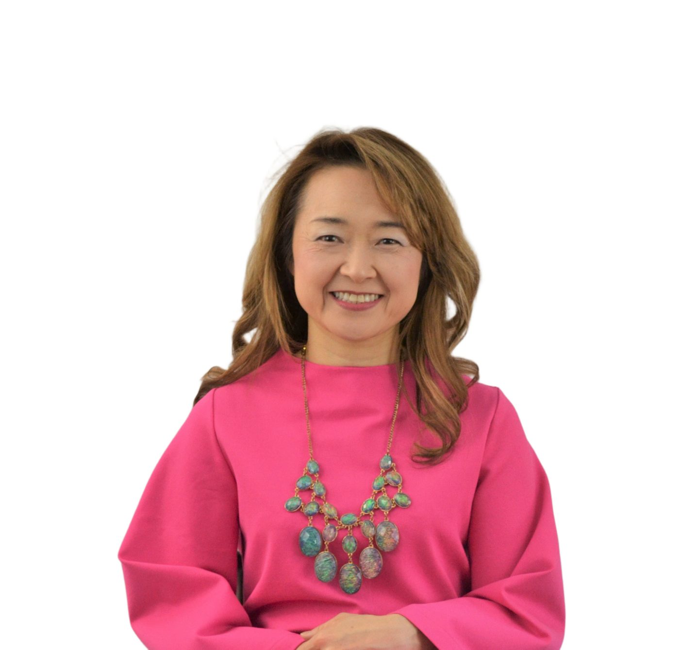 Meg, founder of StudioMeggi, smiling in a bright pink dress with statement jewelry